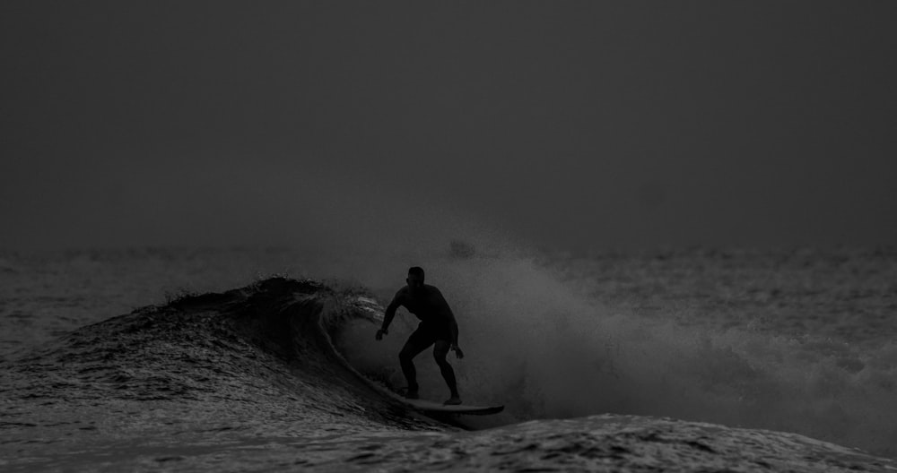 a man riding a wave on top of a surfboard