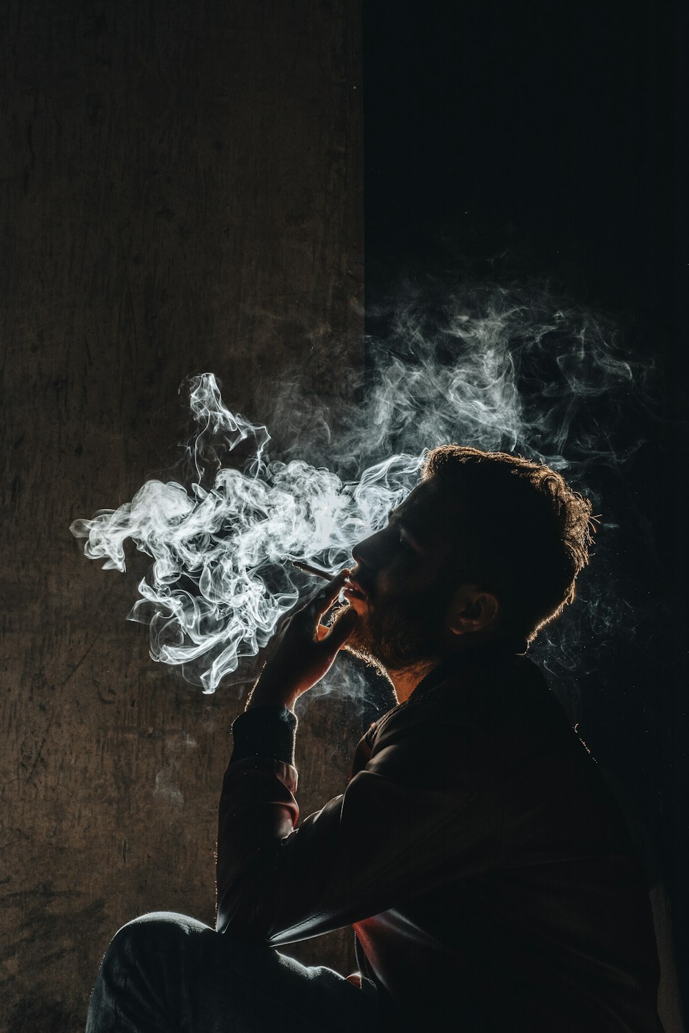 Un homme fumant une cigarette dans le noir