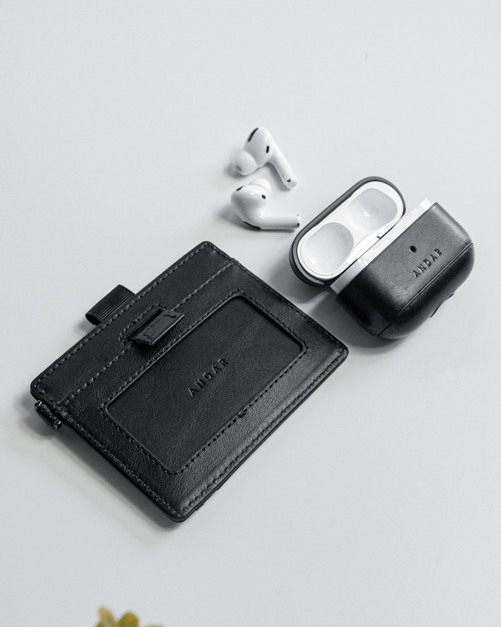 a wallet, headphones, and ear buds on a table