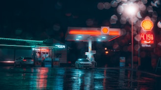 a gas station at night with a car parked in front of it