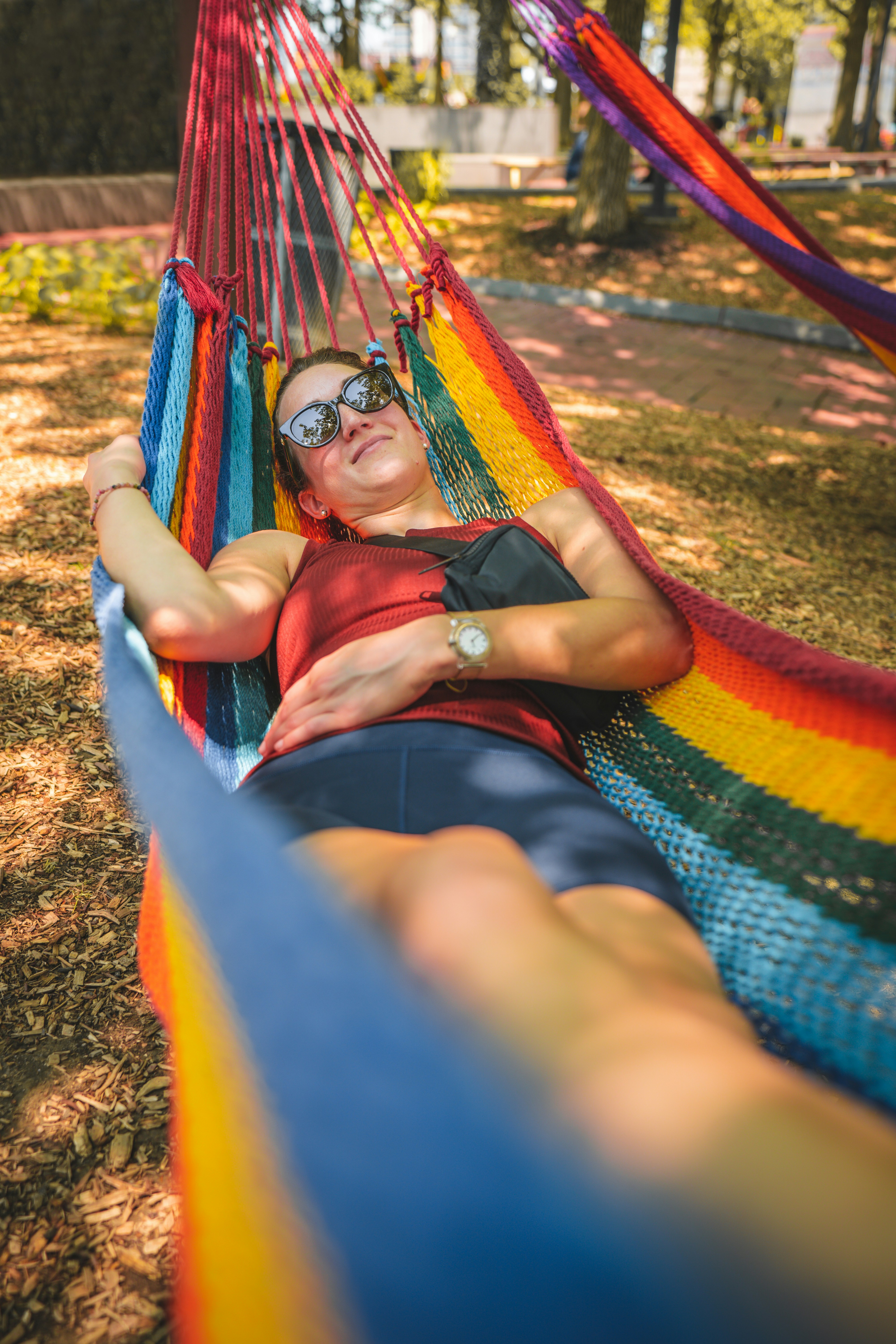 a woman laying in a rainbow colored hammock