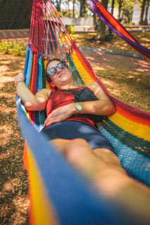 a woman laying in a rainbow colored hammock