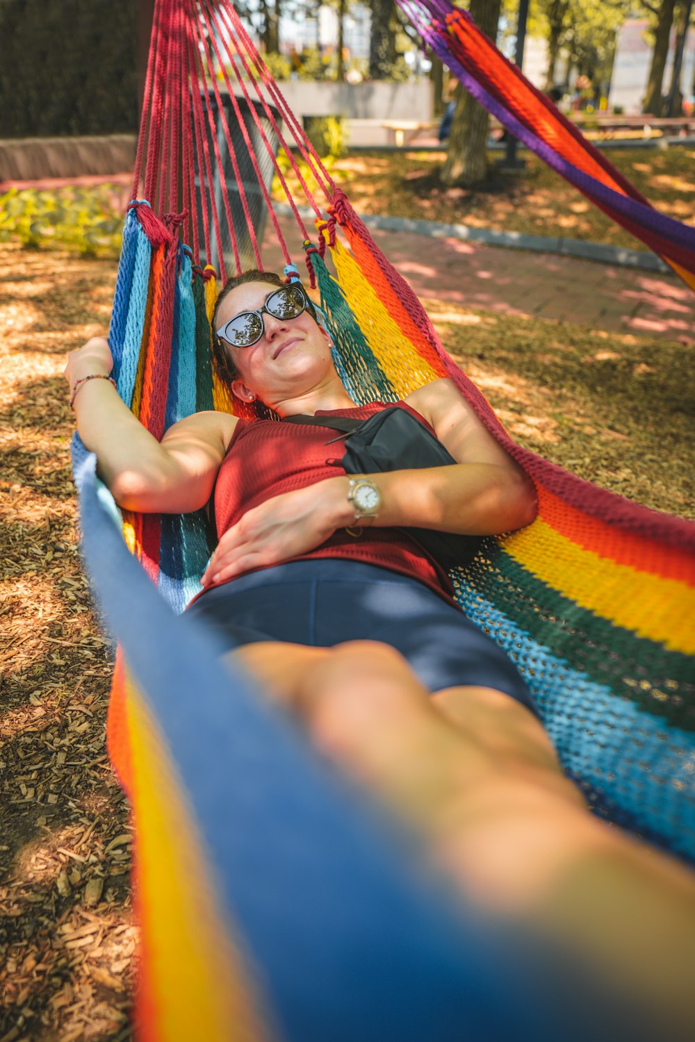 a woman laying in a rainbow colored hammock