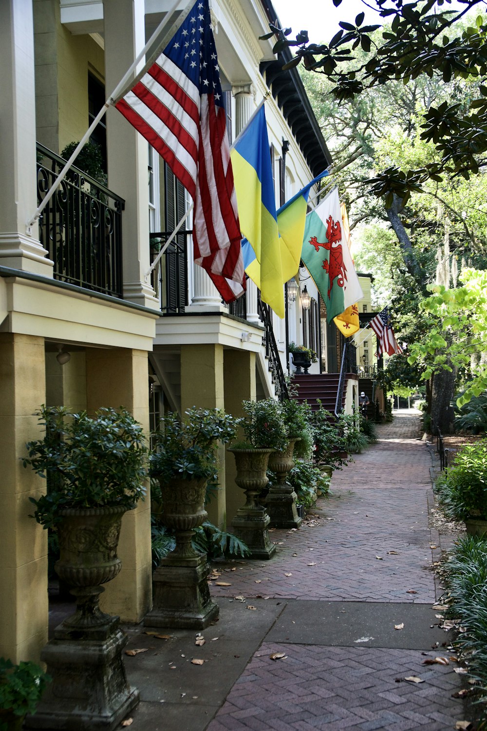 a row of houses with flags hanging from the balconies