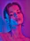 Portrait of a joyful woman glowing with health, surrounded by soft pink neon light.