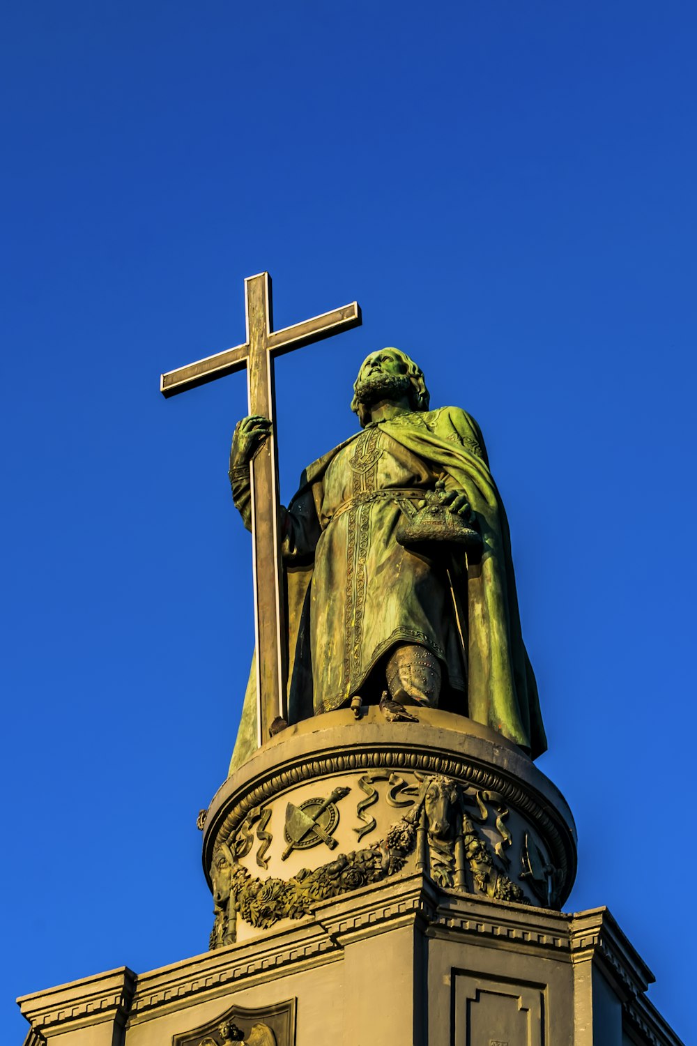 a statue of a man holding a cross on top of a building