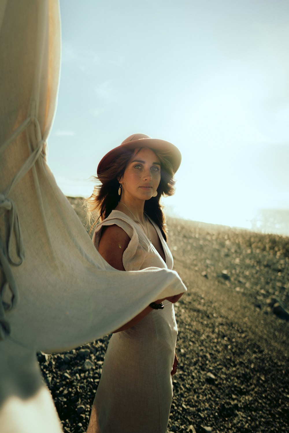 a woman wearing a hat standing on a beach