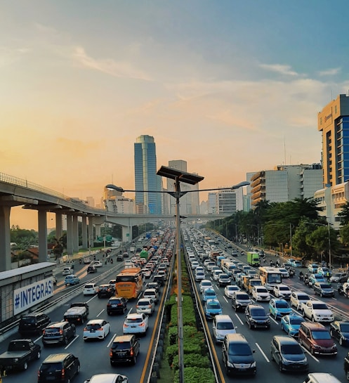 a highway filled with lots of traffic next to tall buildings