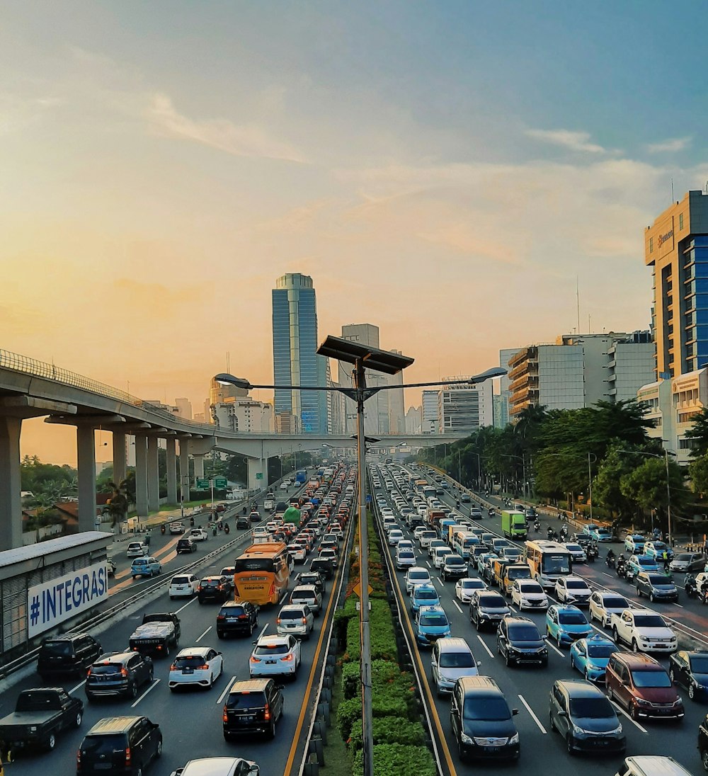 a highway filled with lots of traffic next to tall buildings