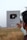 A person holds a YouTube Silver Play Button award, which is given for achieving 100,000 subscribers. The background features a field under a clear sky.
