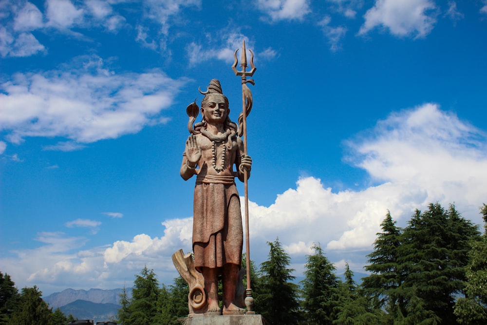 a statue of a person holding a staff