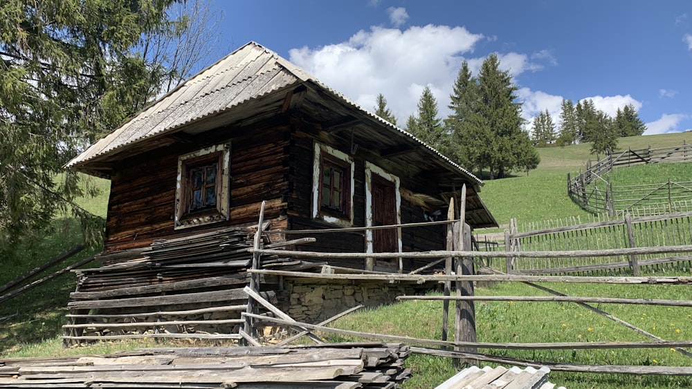 a small wooden cabin sitting on top of a lush green hillside