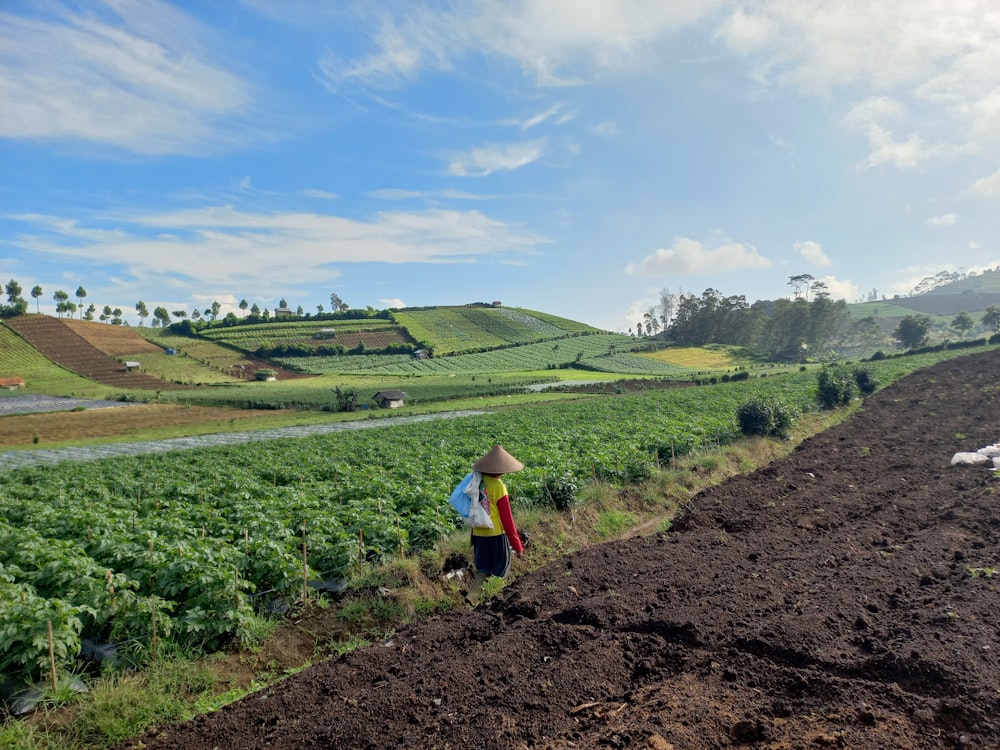 a person standing in a field with a hat on