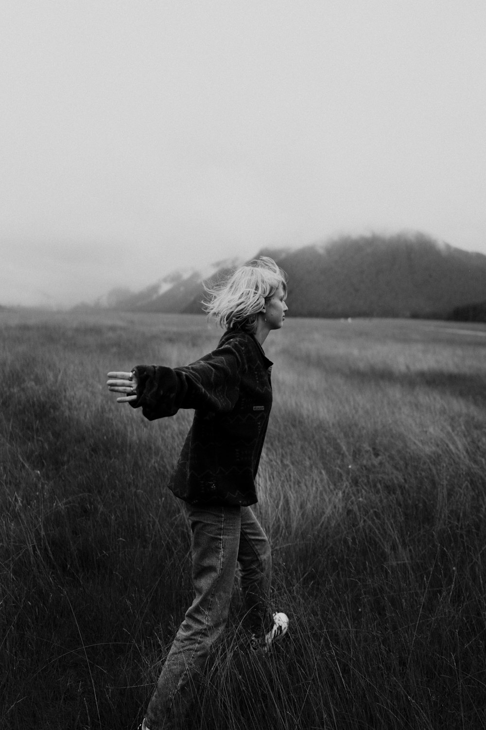 a black and white photo of a woman in a field