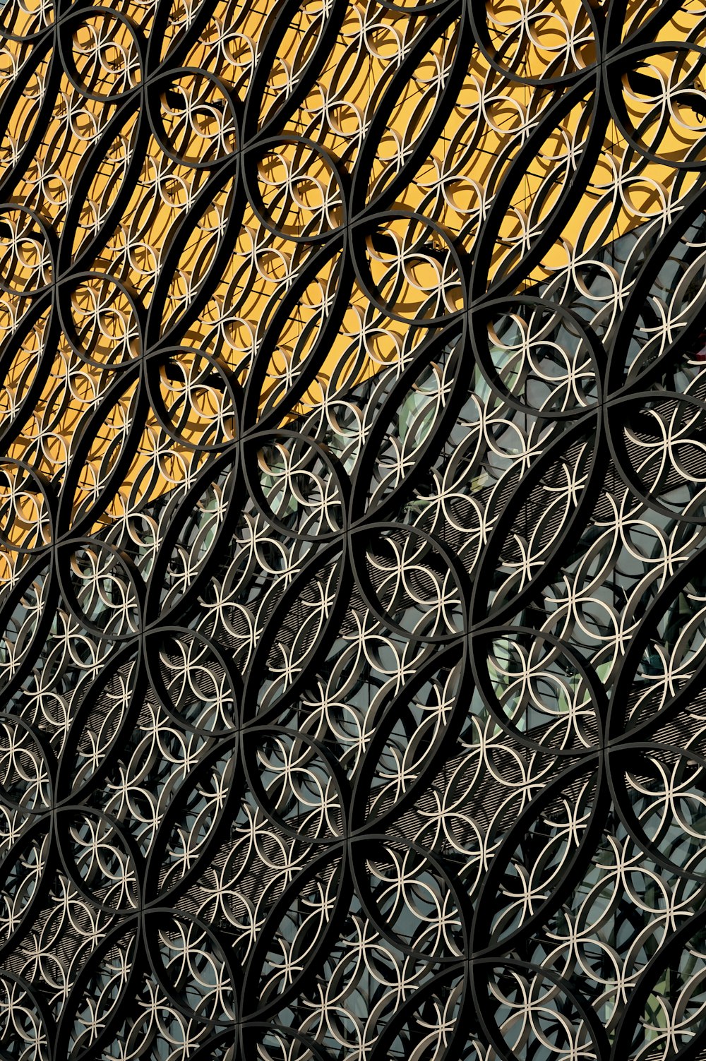 a close up of a metal fence with a building in the background