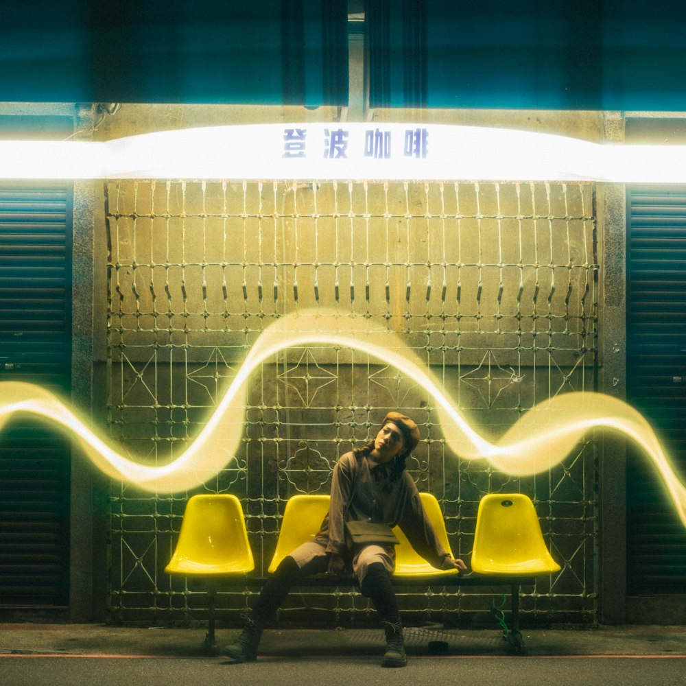 a man sitting on a bench in front of a wall