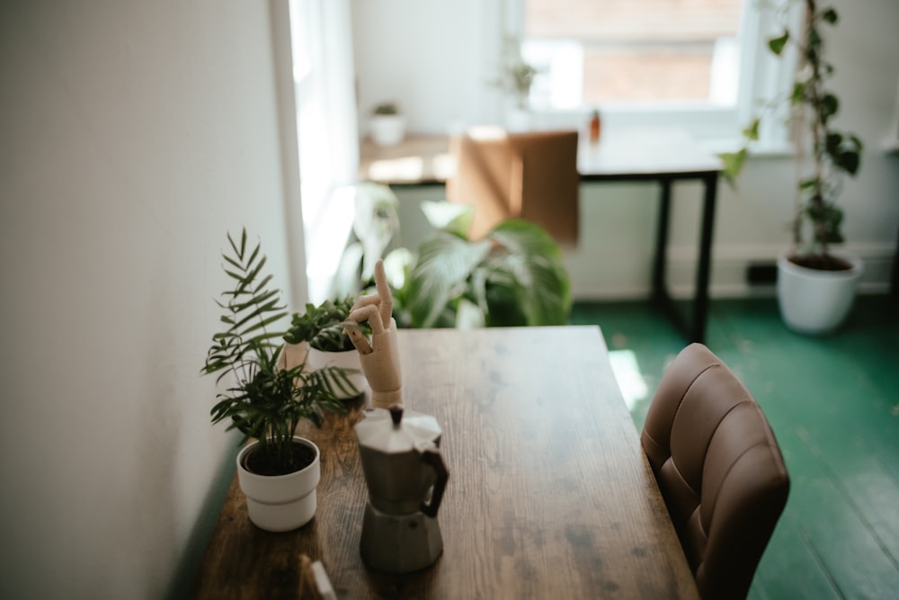 a wooden table topped with potted plants next to a window