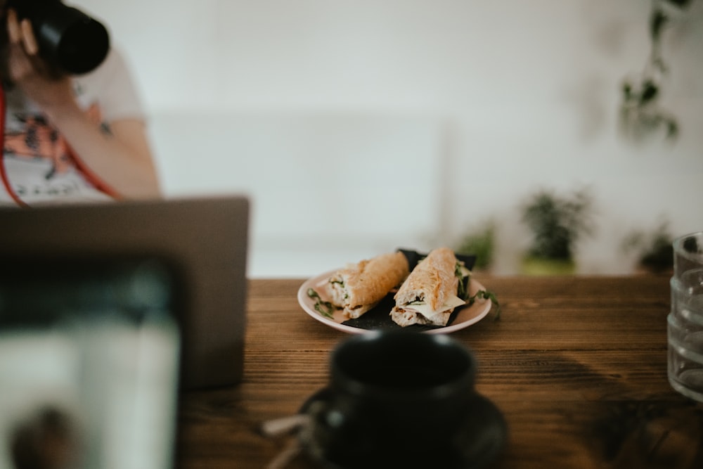 a woman taking a picture of food on a plate