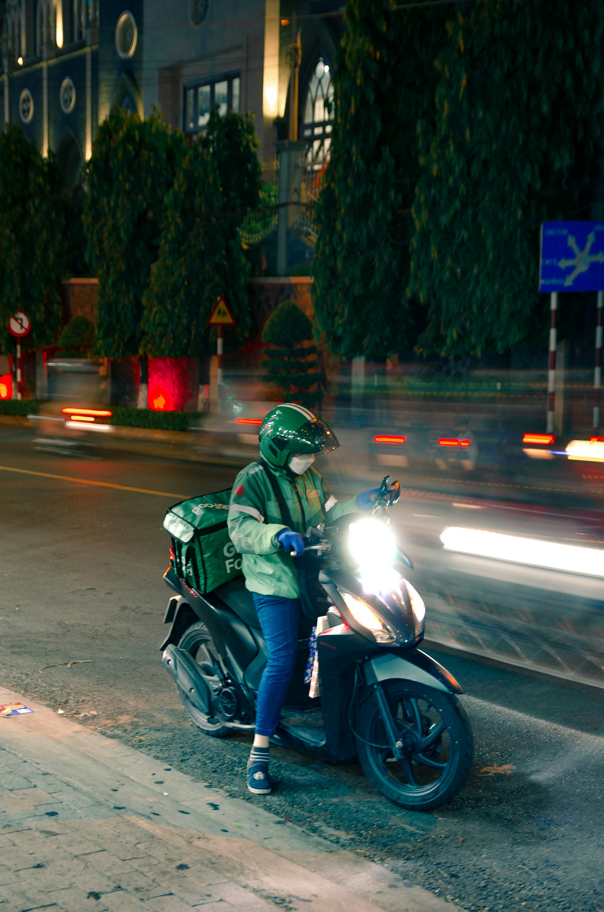 a man riding a motorcycle down a street at night
