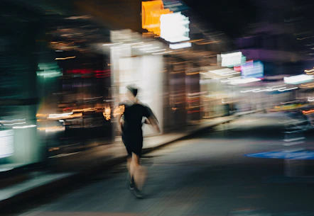 a blurry image of a man riding a skateboard on a city street