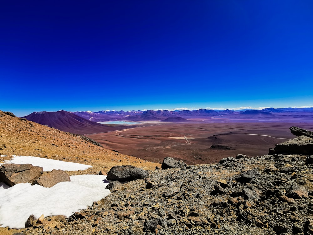 a view of a mountain range with snow on the ground