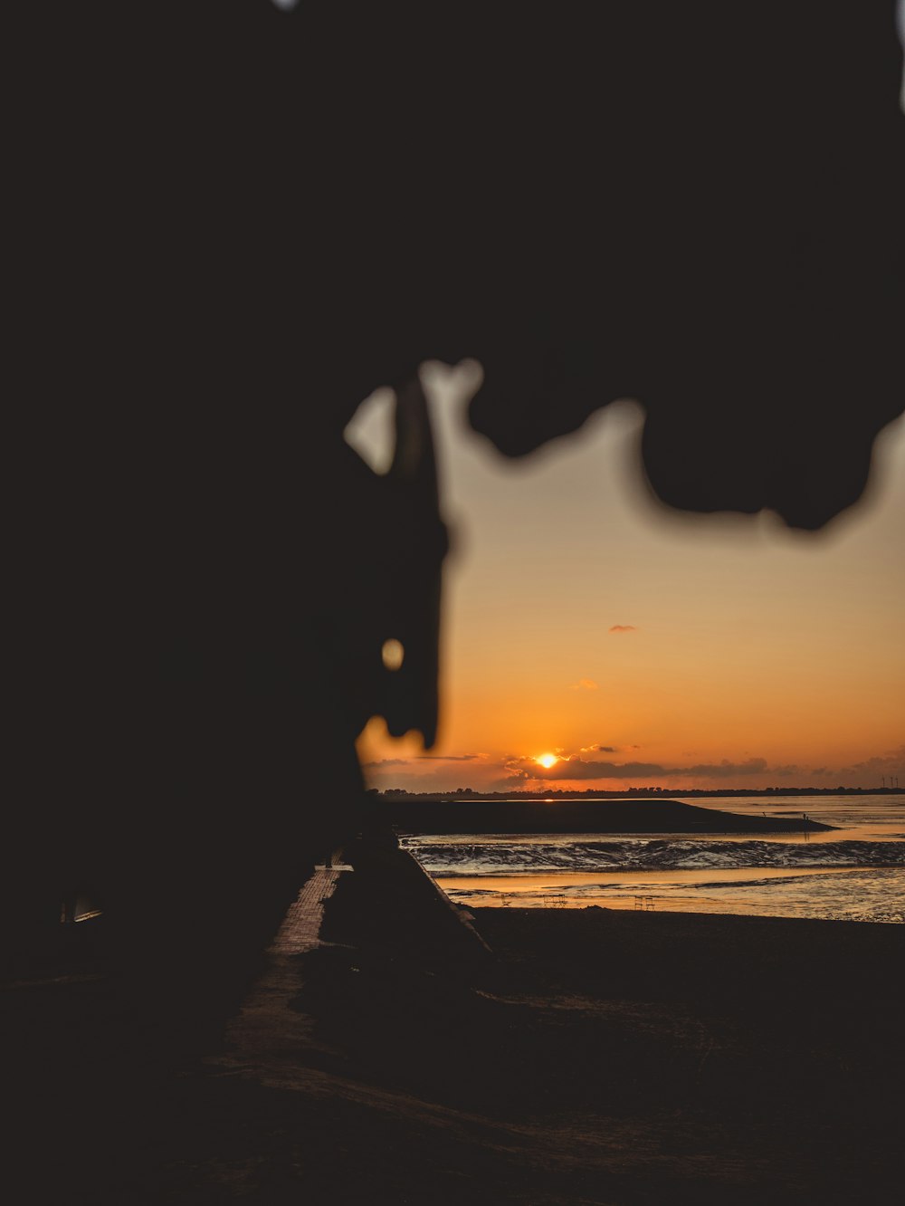 the sun is setting over the ocean as seen through a window