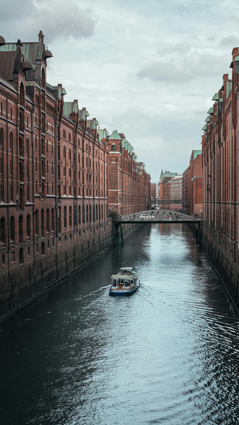 a boat traveling down a river next to tall buildings