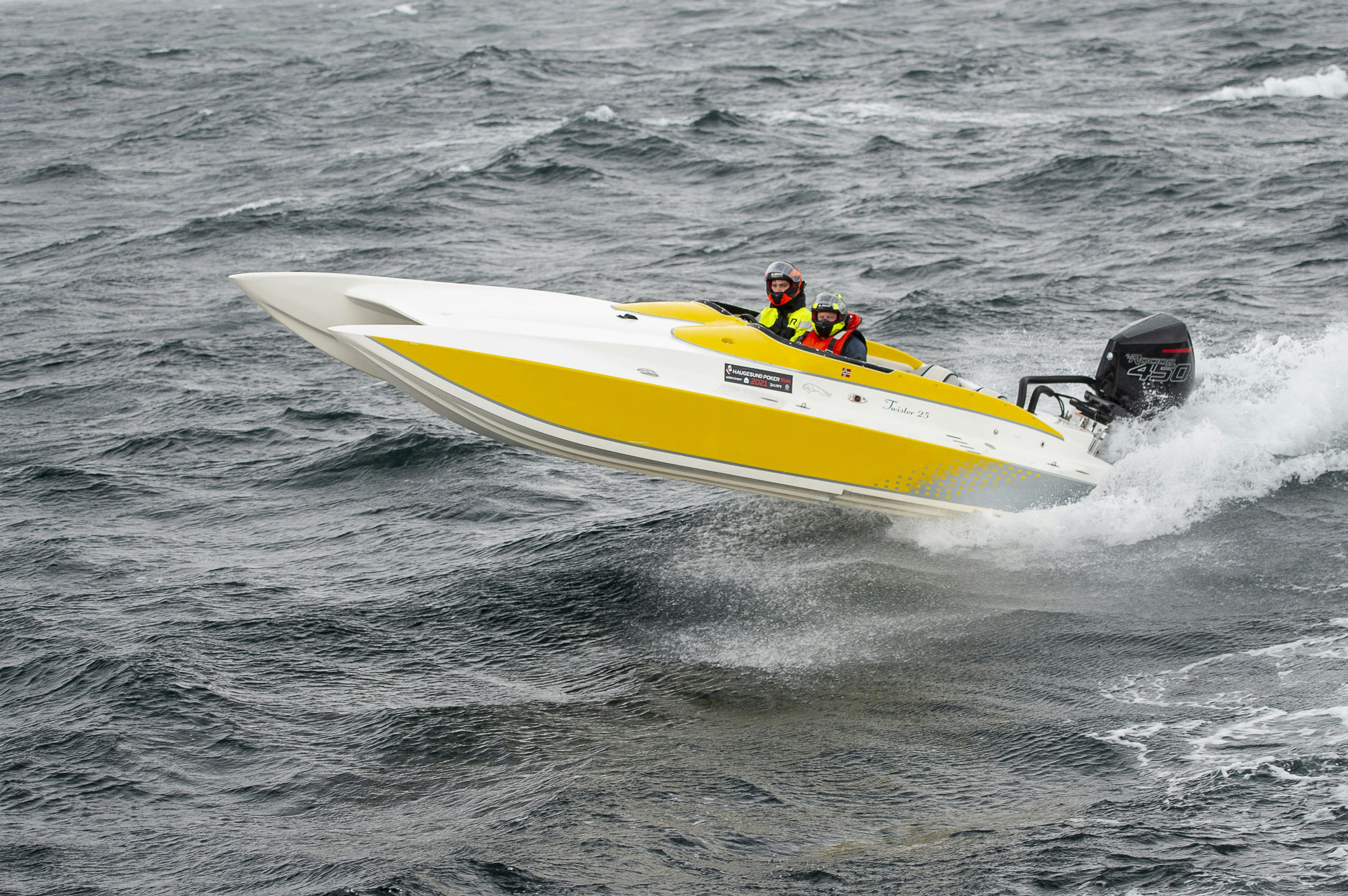 a man riding on the back of a yellow and white boat