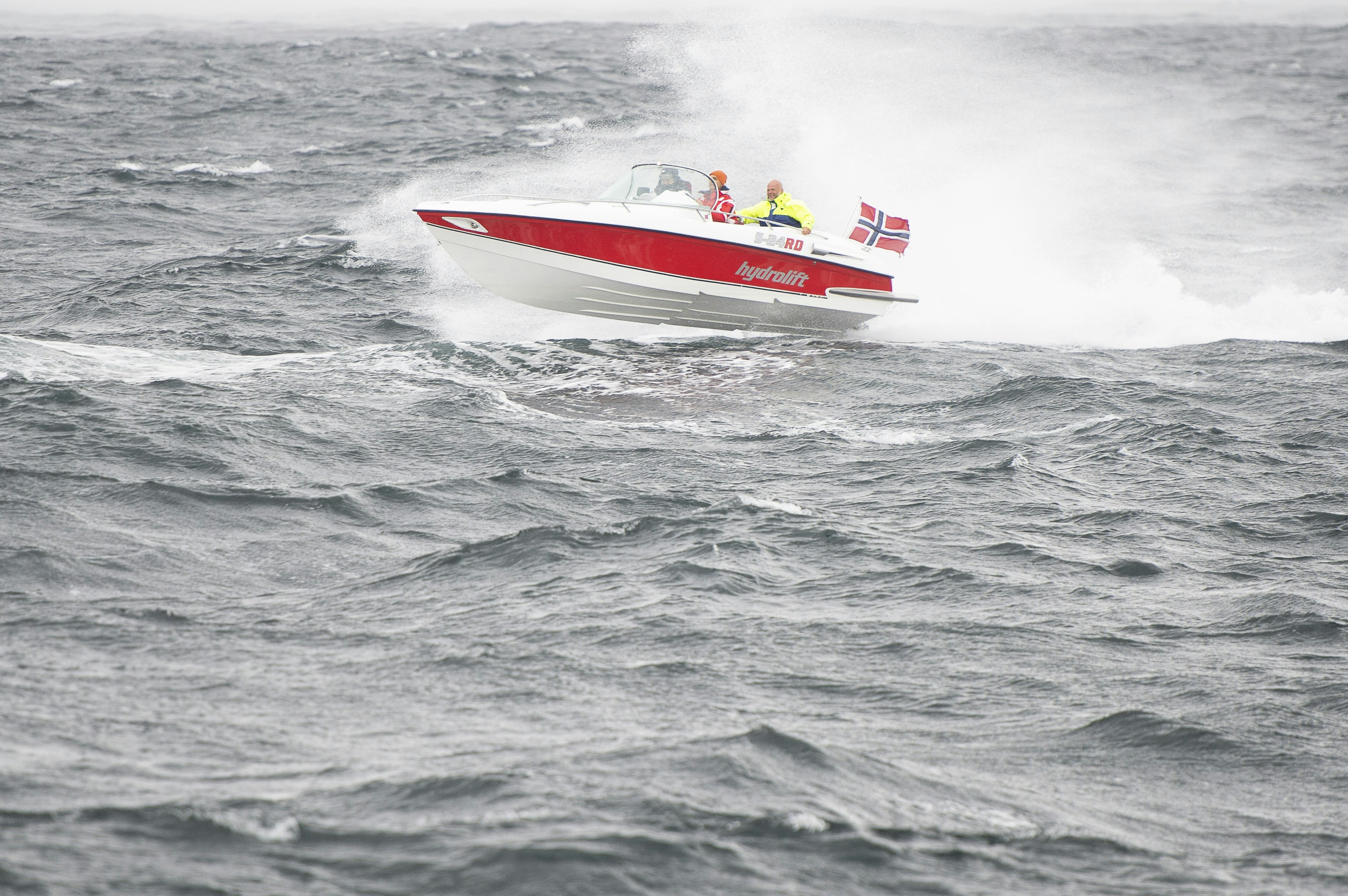 a red and white boat in the middle of the ocean