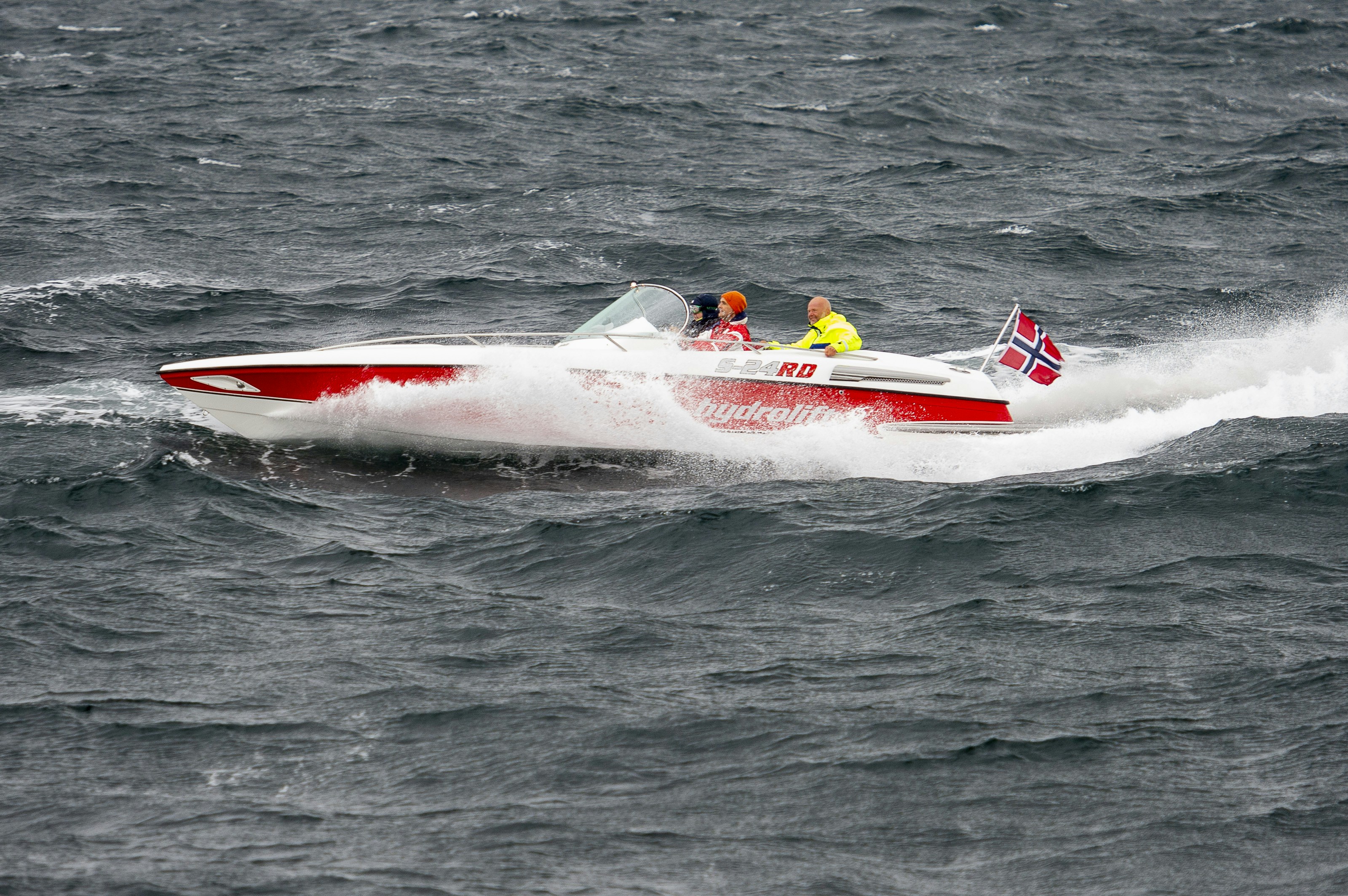 a red and white speed boat in the middle of the ocean