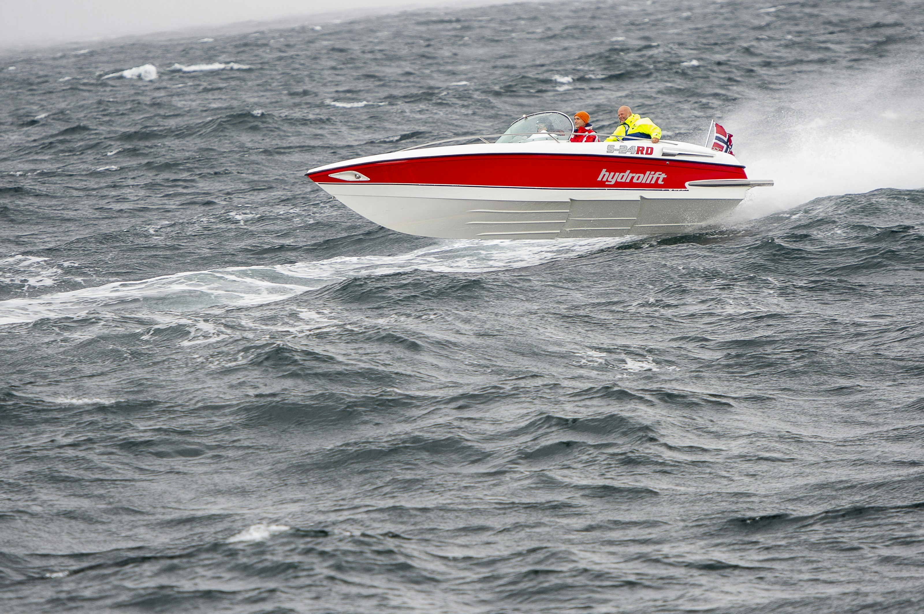 a red and white speed boat in the middle of the ocean