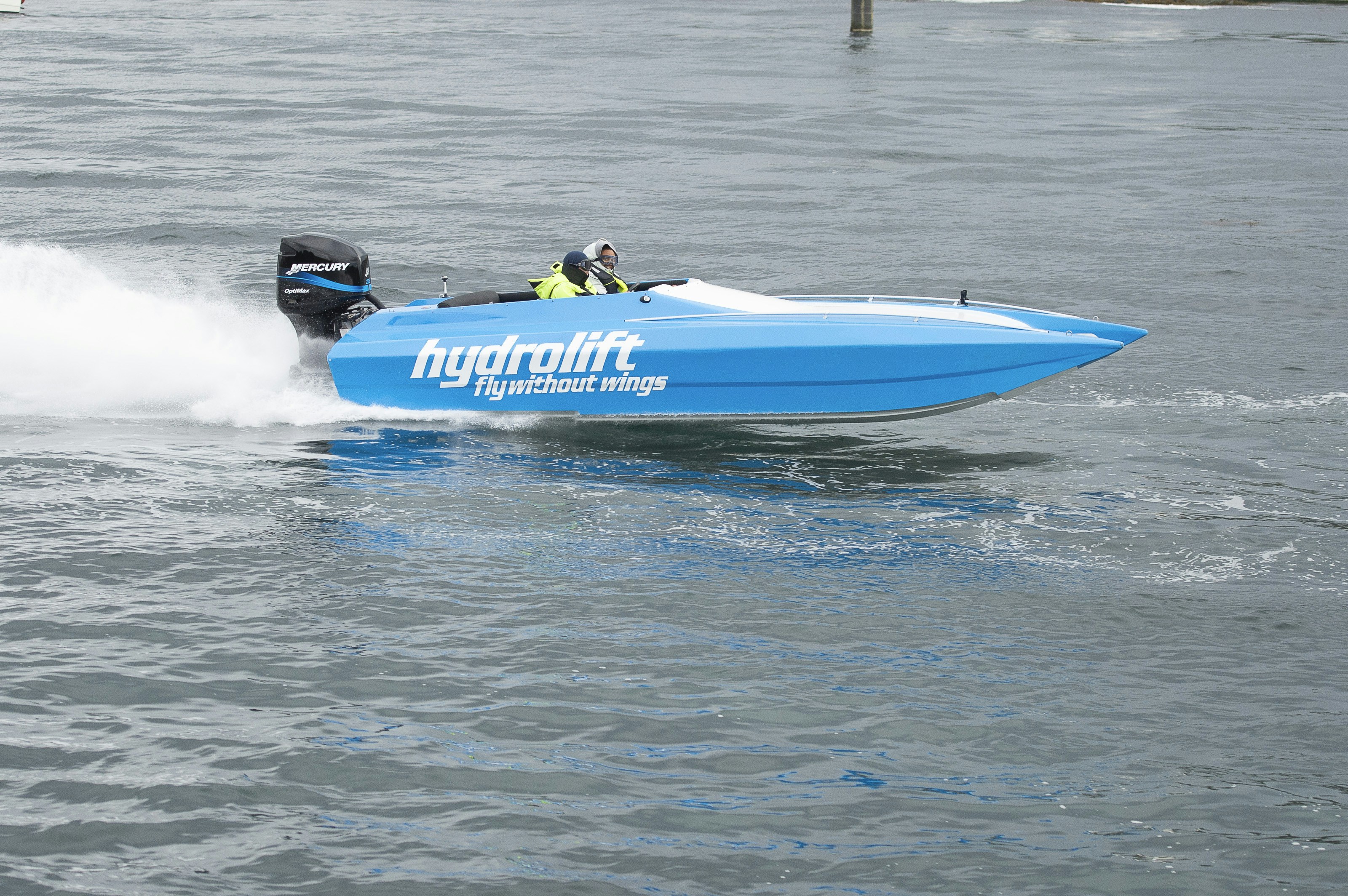 a blue speed boat speeding across a body of water