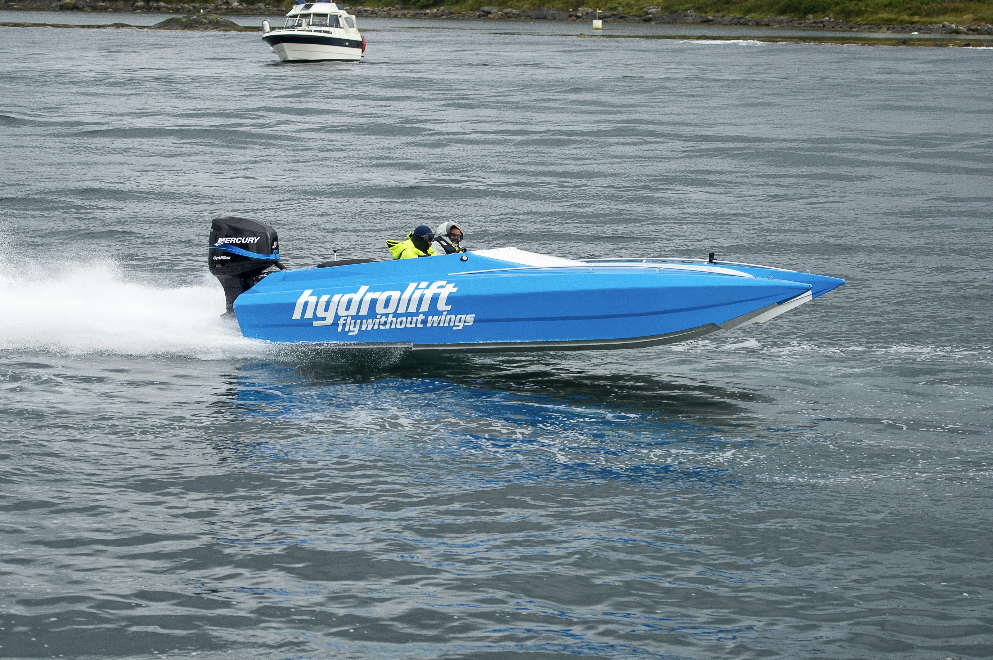 a blue speed boat speeding across a body of water