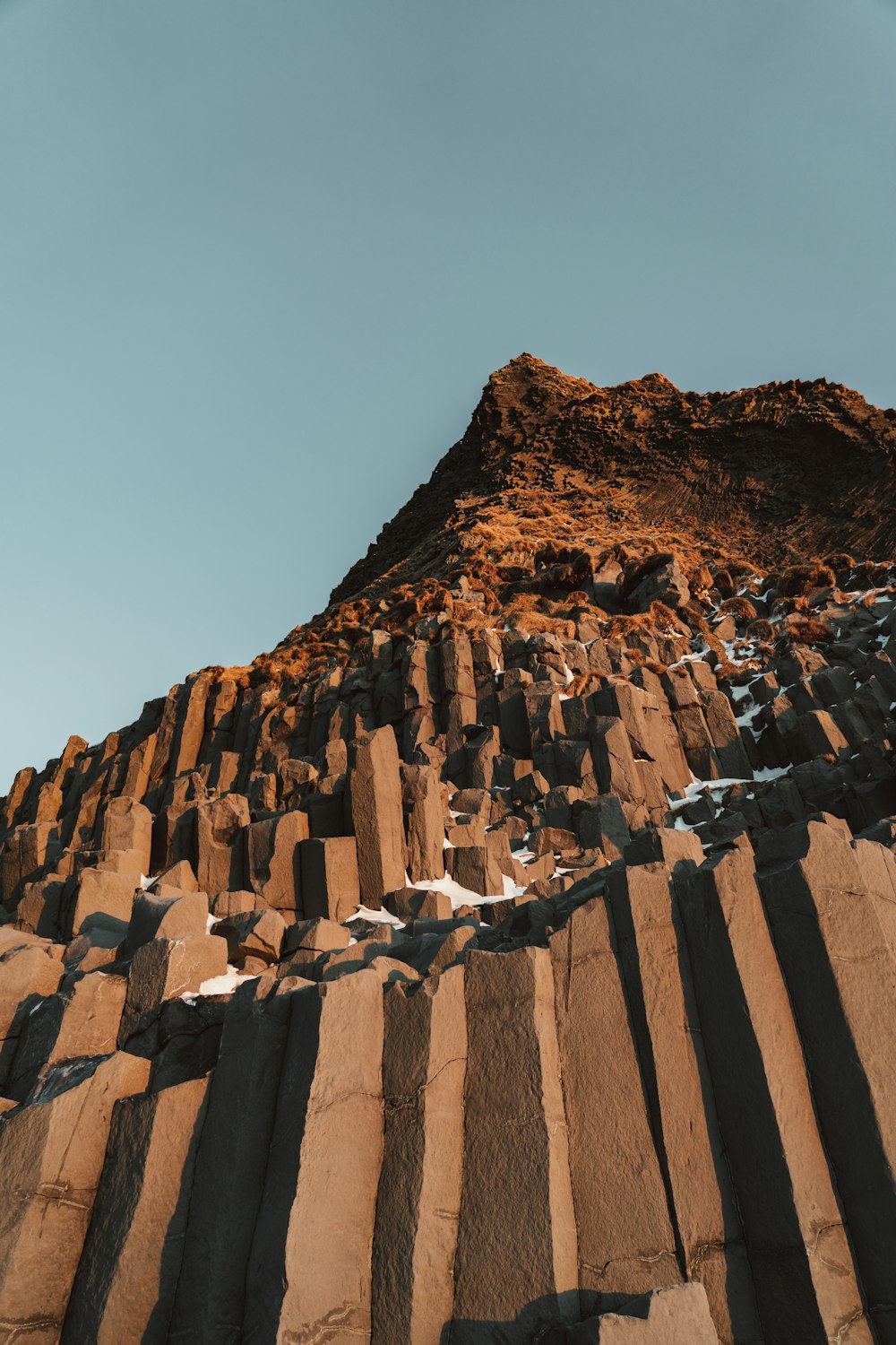 a very tall rock formation with a sky background