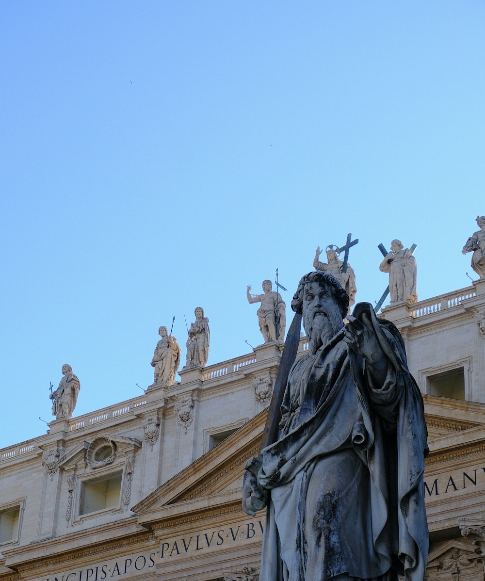 a statue in front of a building with statues on it