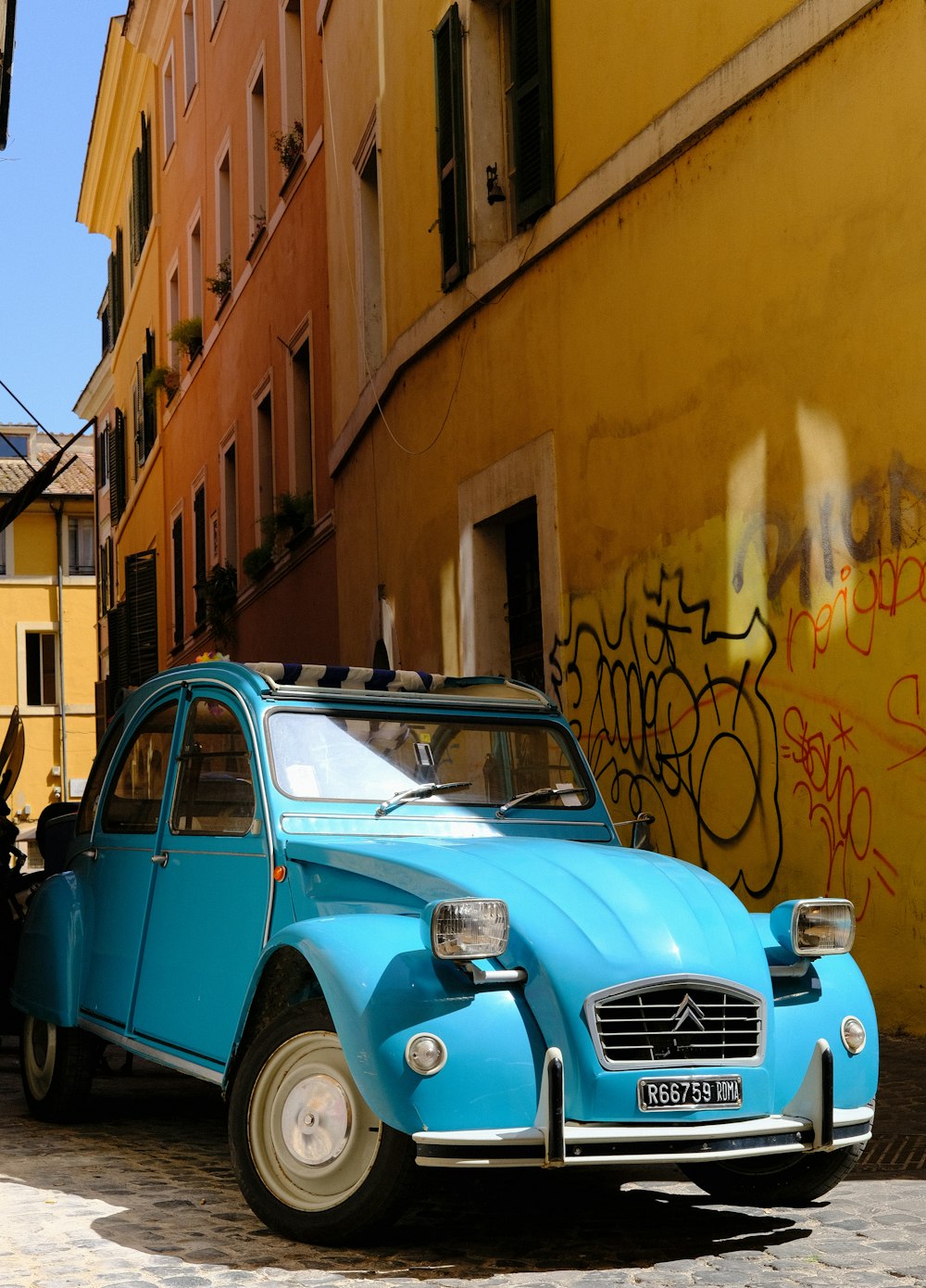 a blue car parked in front of a yellow building