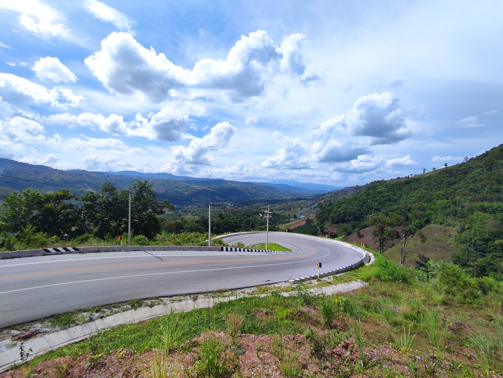 a curved road with a mountain in the background