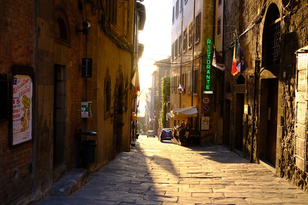 a narrow city street with a cobblestone sidewalk
