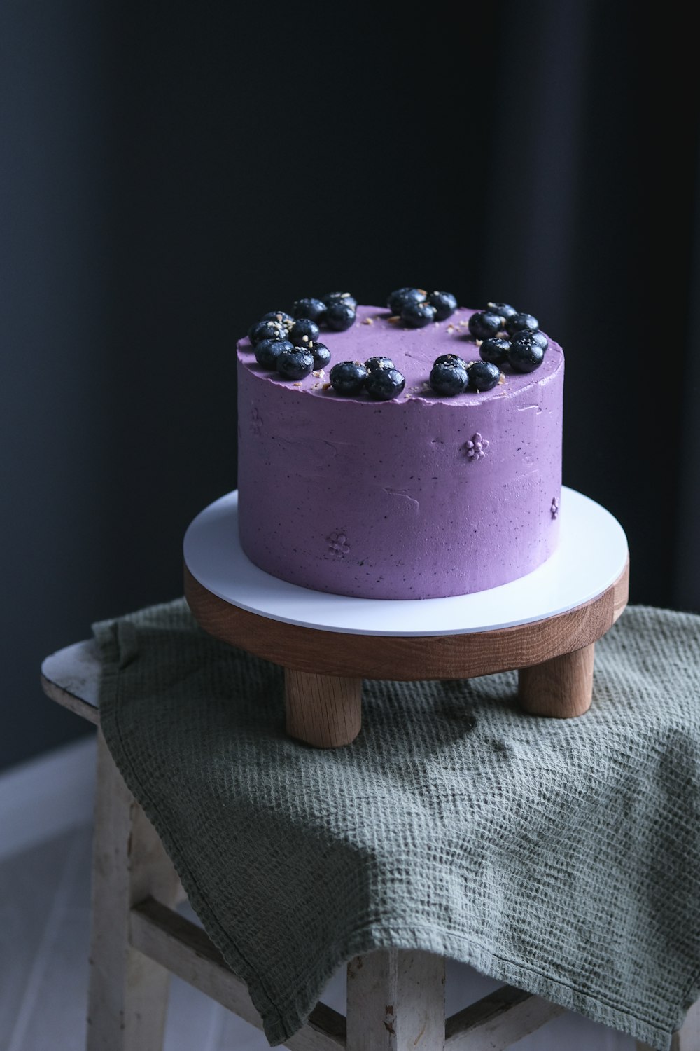 a blueberry cake sitting on top of a wooden table