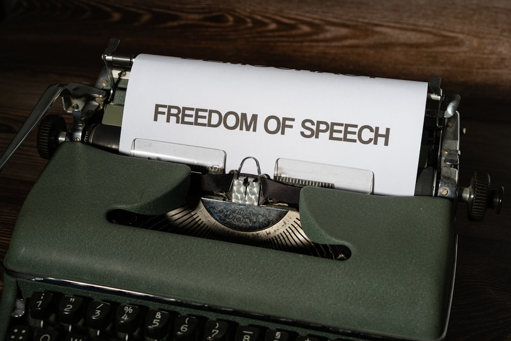 a typewriter with a paper that reads freedom of speech