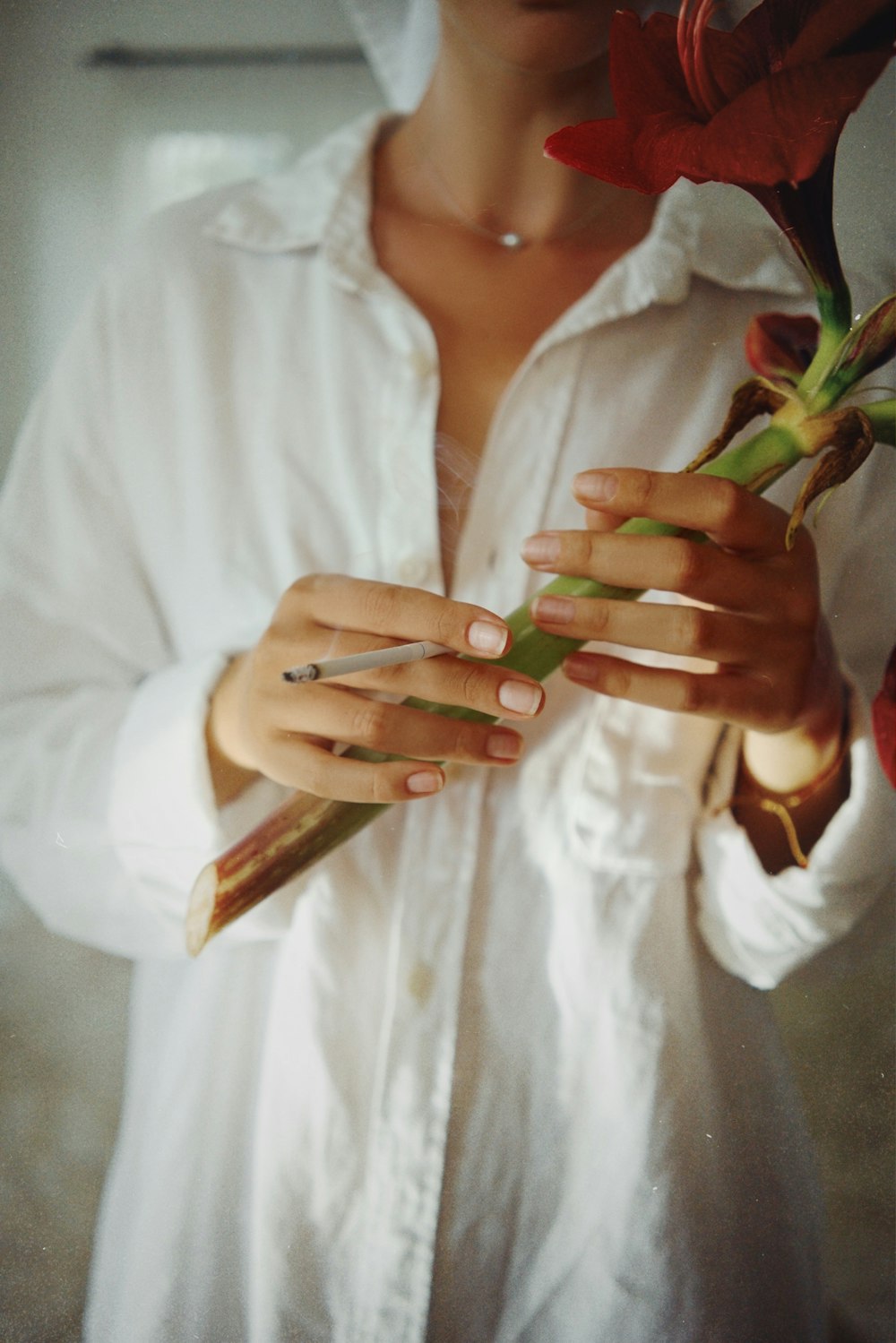 a woman in a white shirt holding a flower