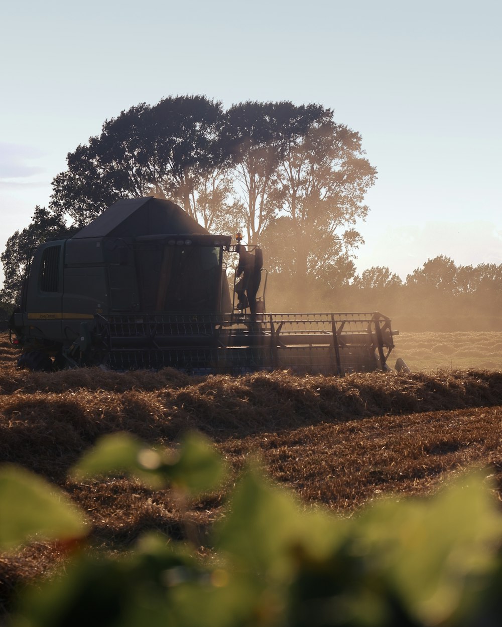 a tractor is driving through a field with hay