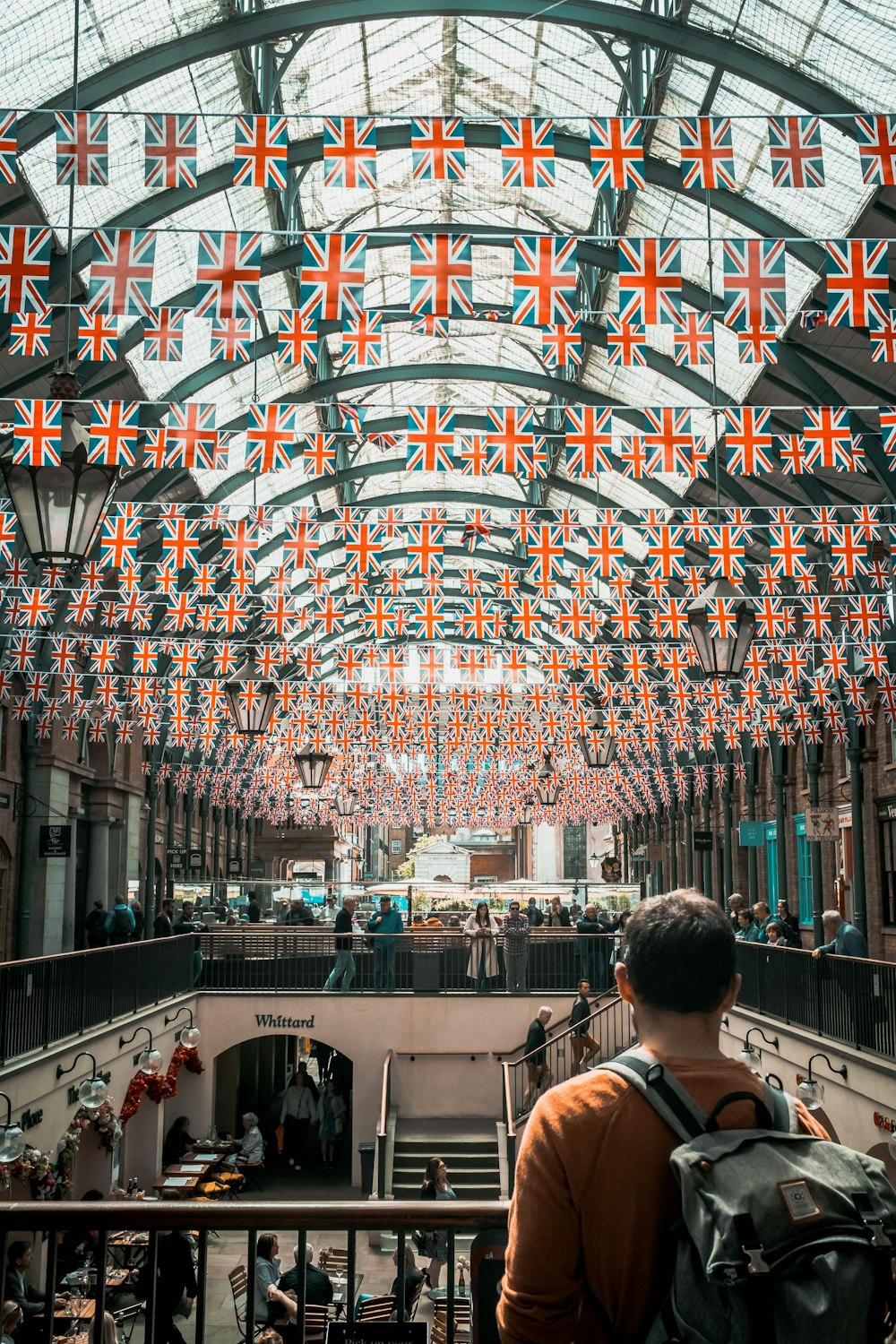 a man standing in a building with a lot of flags hanging from the ceiling