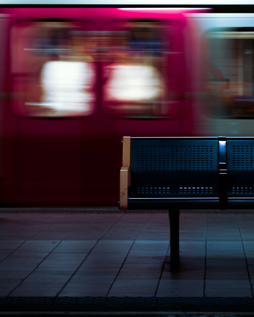 a bench on a sidewalk in front of a train