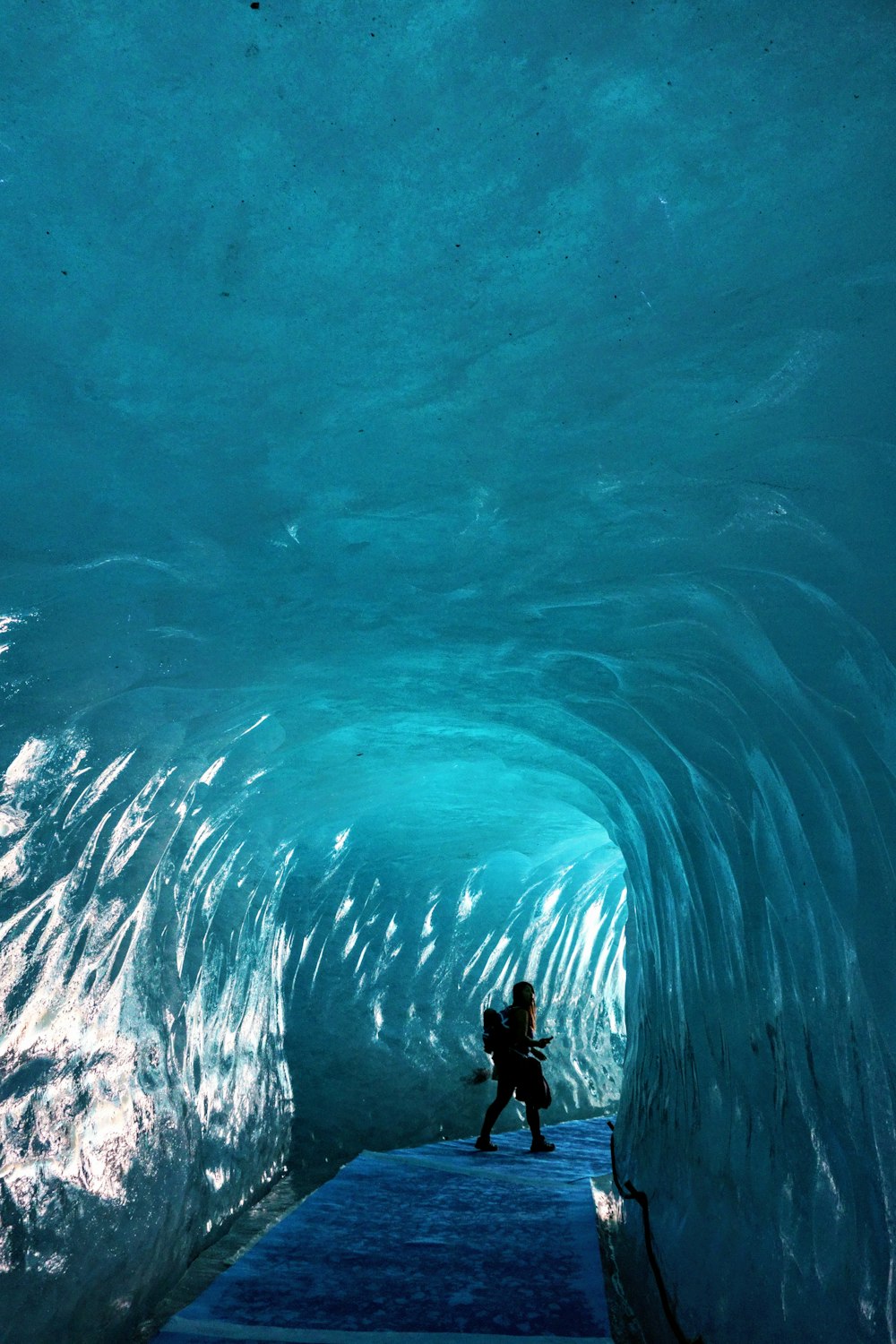 a person standing in a tunnel of ice