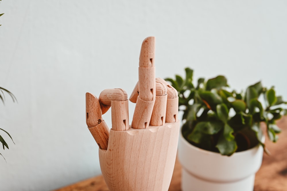 a wooden sculpture of a hand holding two fingers