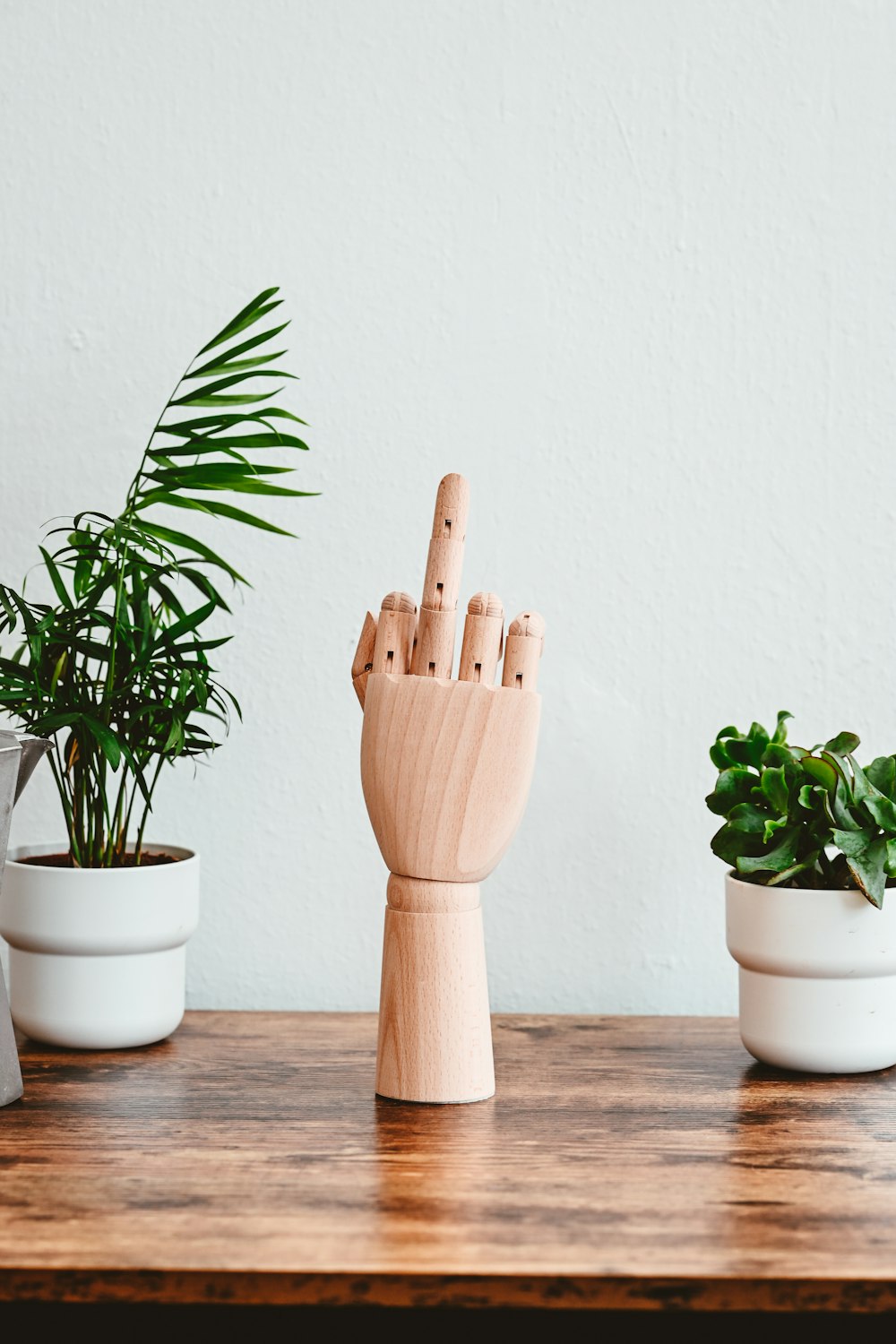 a wooden sculpture of a hand is on a table