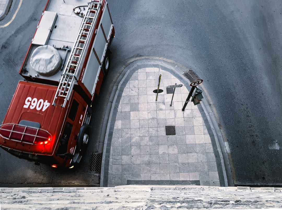 a fire truck parked on the side of a road, a firetruck passing by under the gate of Heraklion Walls
