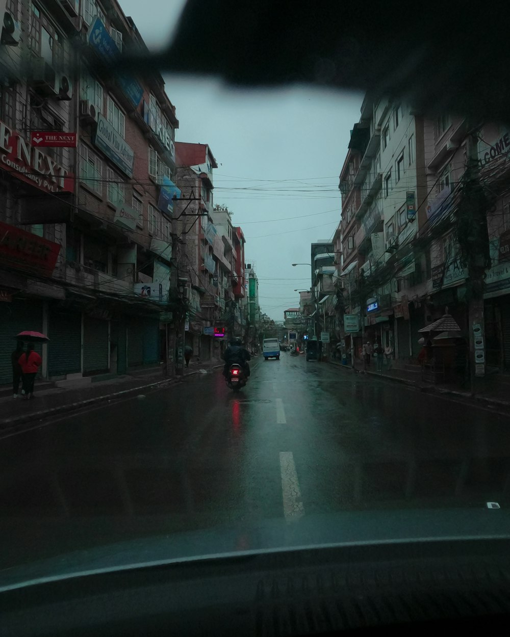 a car driving down a street next to tall buildings