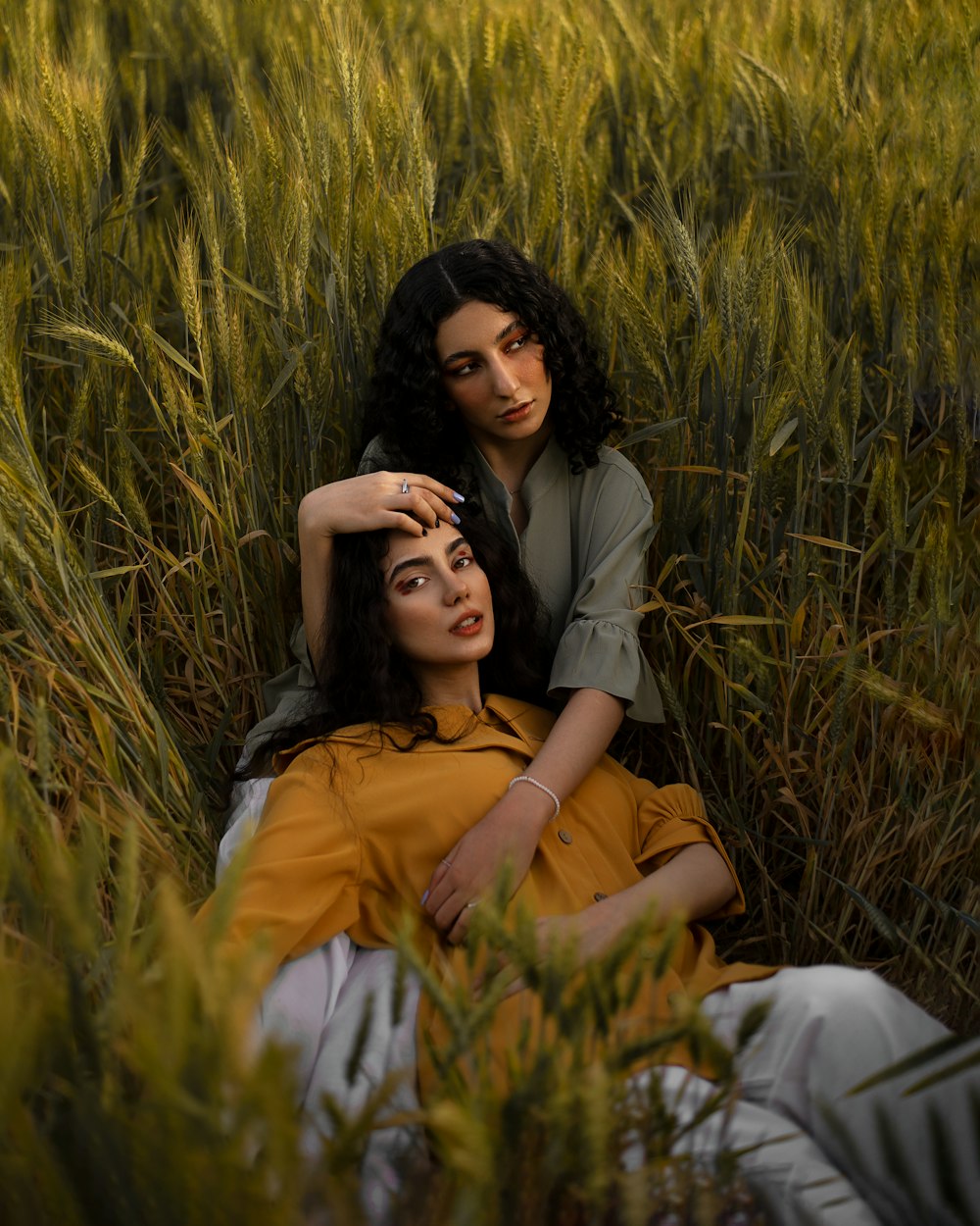 two women laying in a field of tall grass